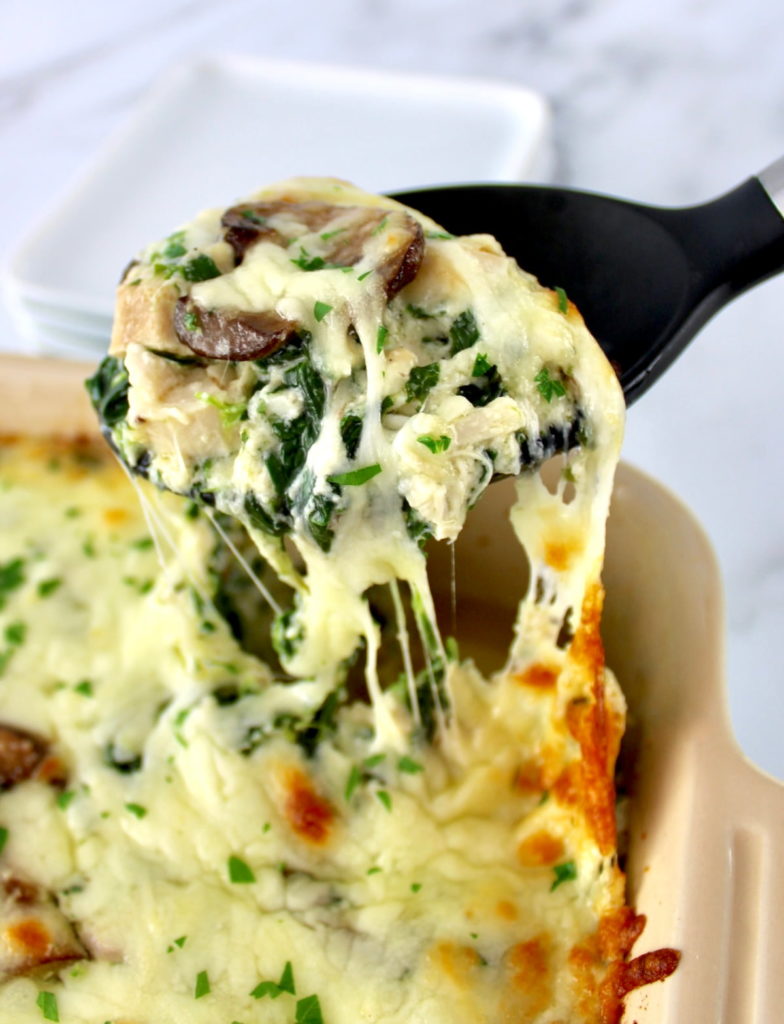 Chicken Alfredo Casserole being scooped out of casserole dish