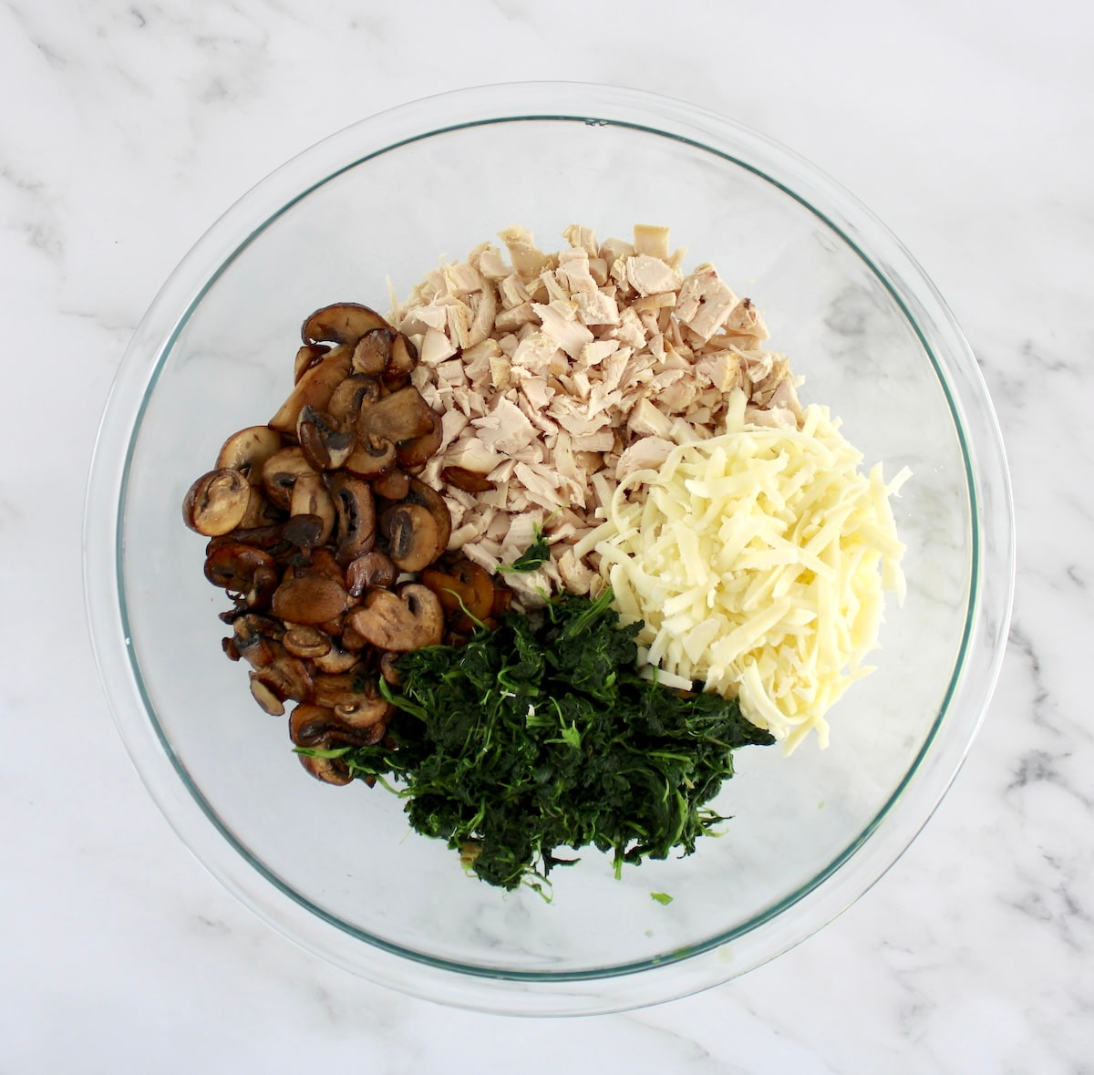 cooked mushrooms, chopped chicken, spinach and mozzarella cheese in glass bowl in groups unmixed