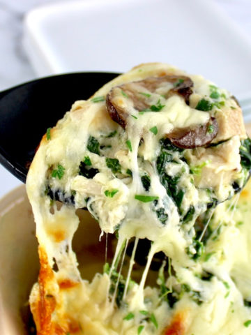 Chicken Alfredo Casserole being scooped of of casserole dish