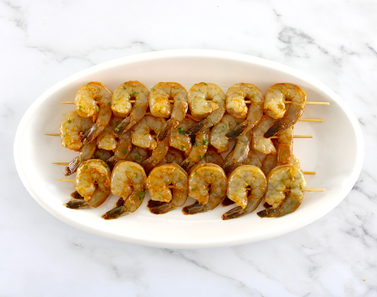Lime Cilantro Shrimp Skewers uncooked on white oval platter