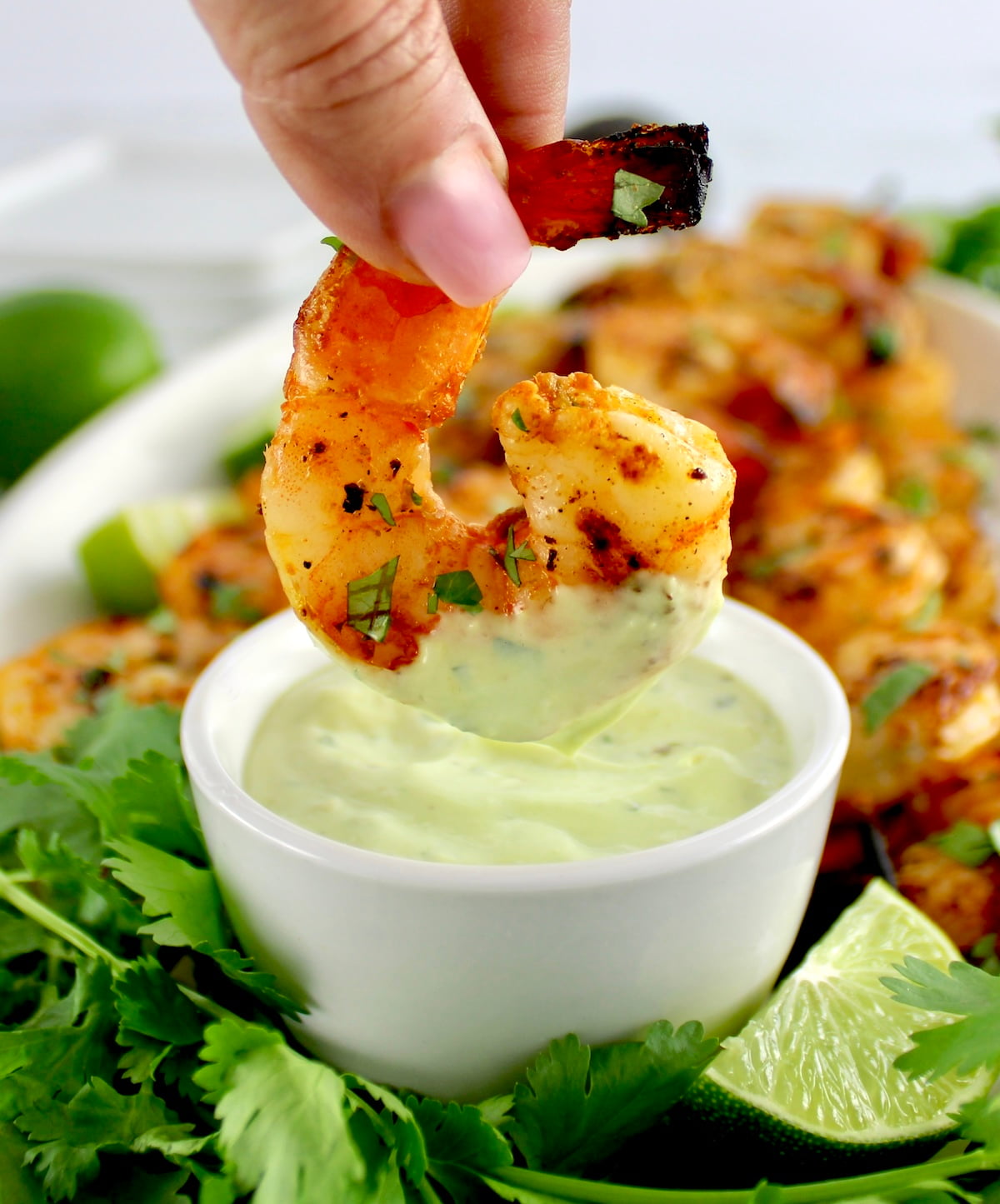 Grilled Lime Cilantro Shrimp being dipped in avocado ranch dressing