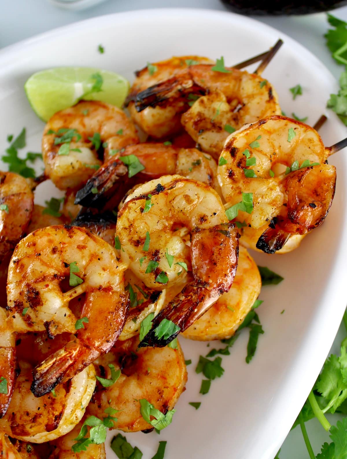 closeup of Grilled Lime Cilantro Shrimp Skewers on white plate