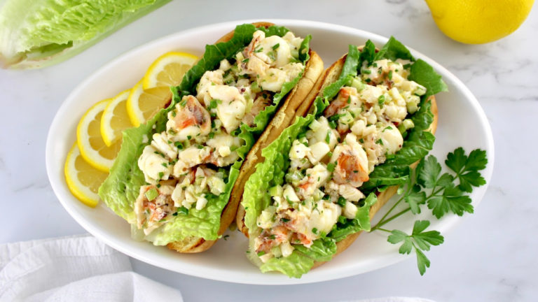 2 Keto Lobster Rolls on white oval platter with parsley and lemon slices garnish on side