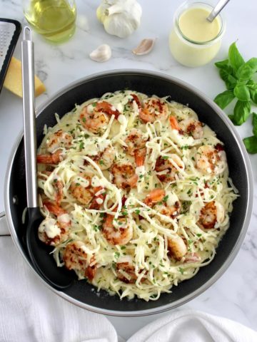 Keto Shrimp Alfredo in skillet with serving spoon