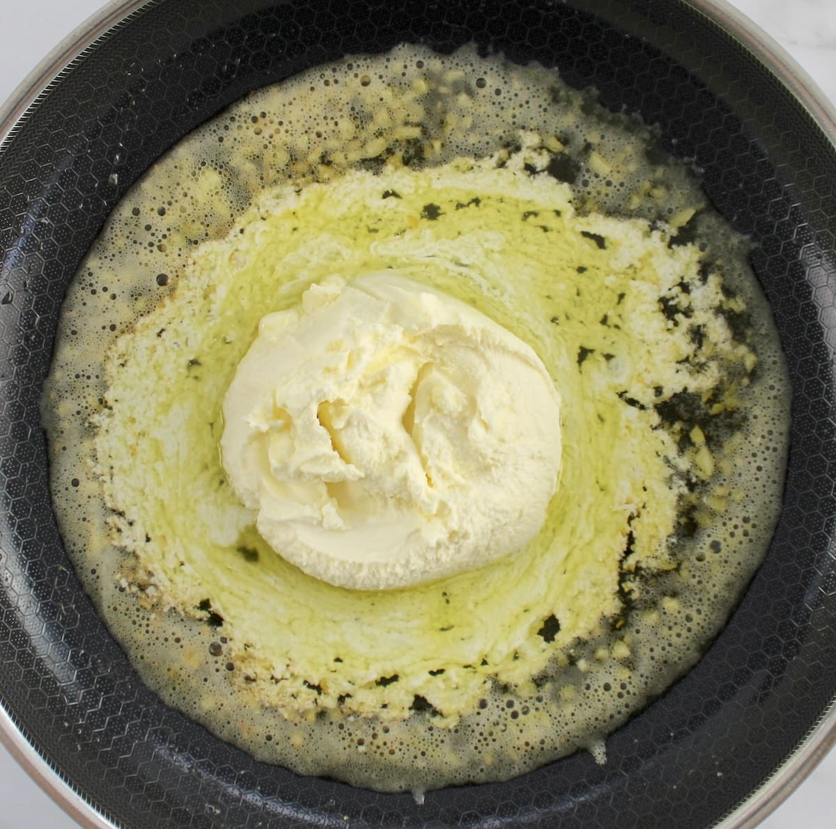 mascarpone cheese melting in butter in skillet