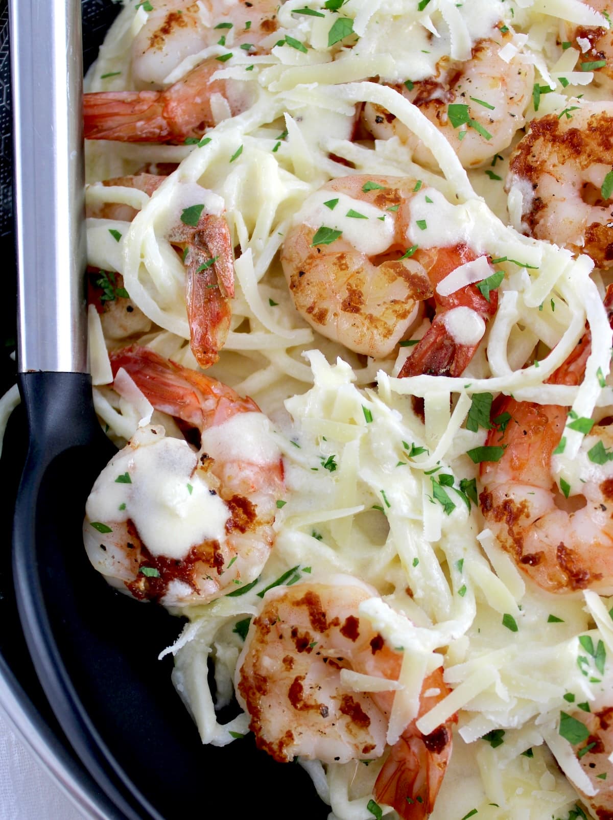 closeup of Keto Shrimp Alfredo in skillet with serving spoon on side