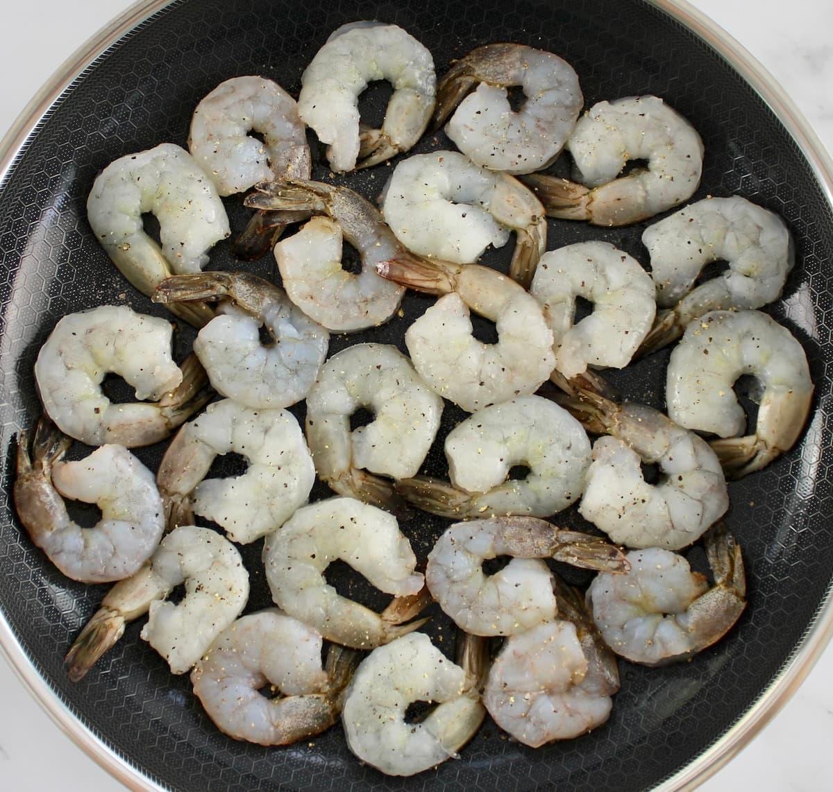 raw jumbo shrimp in skillet