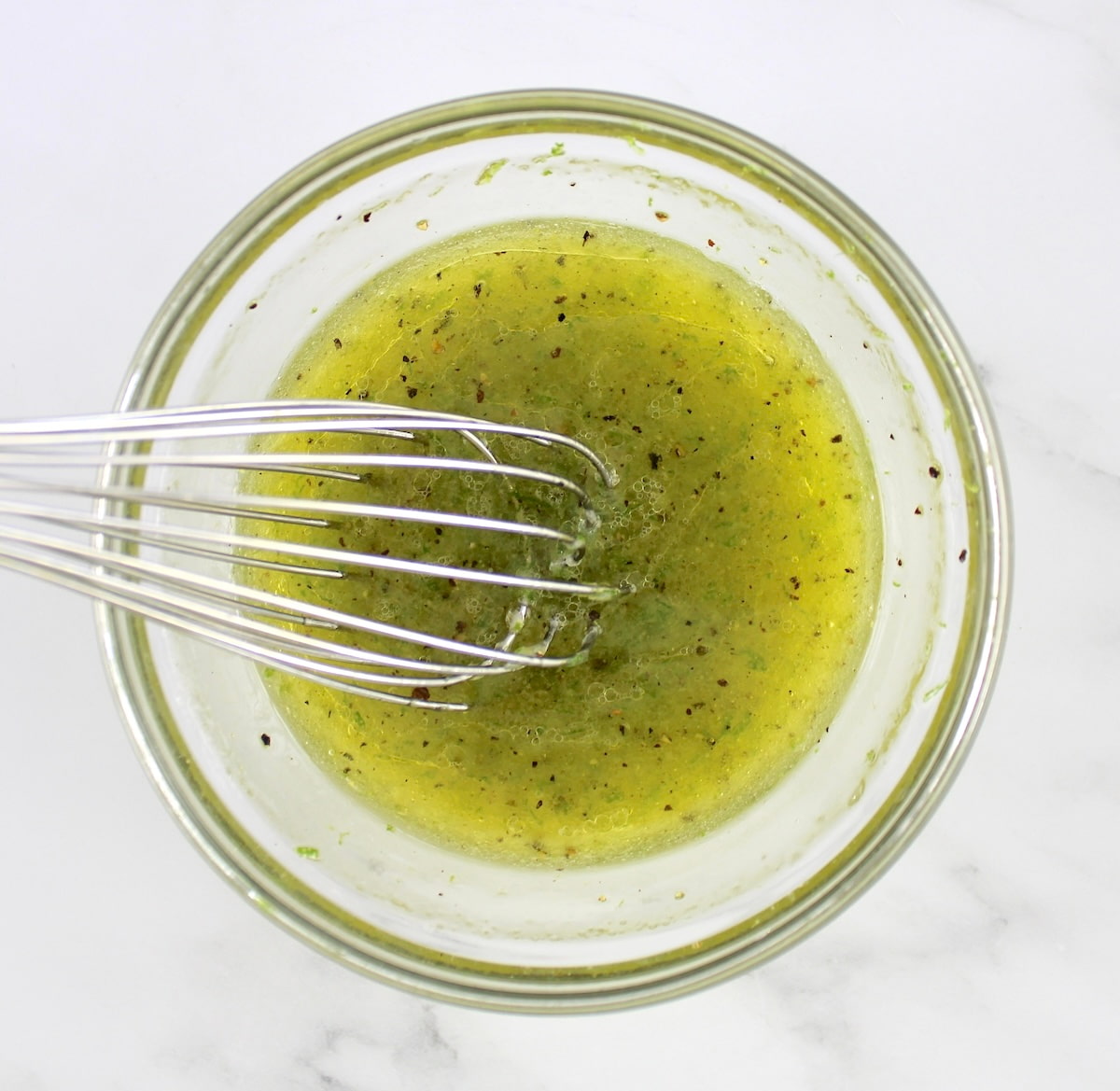 Avocado Salsa dressing in glass bowl with whisk