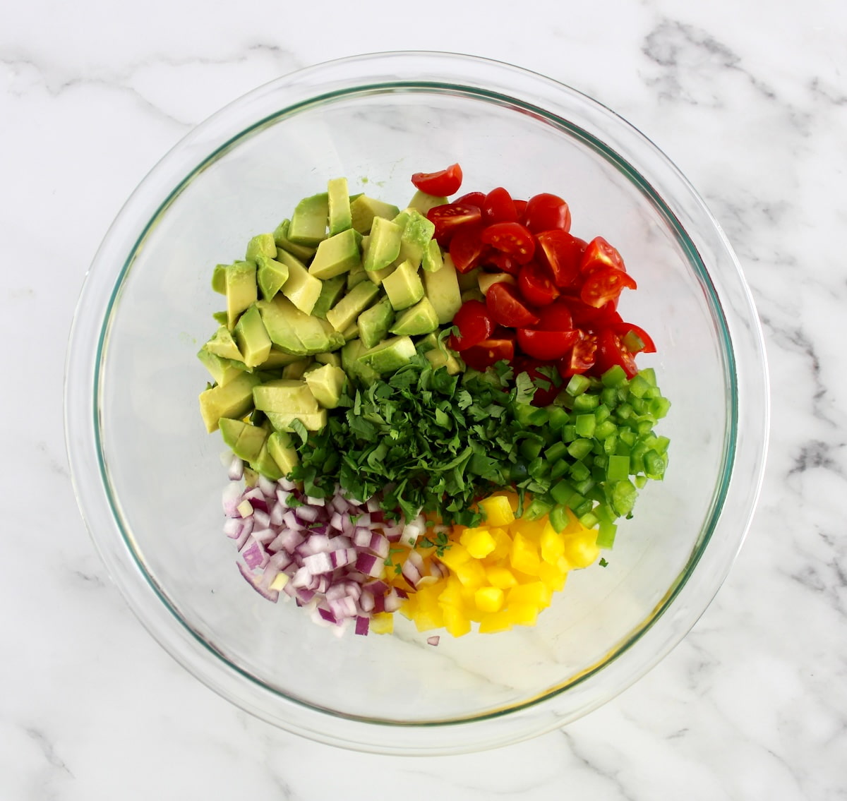 Avocado Salsa ingredients in glass bowl in groups
