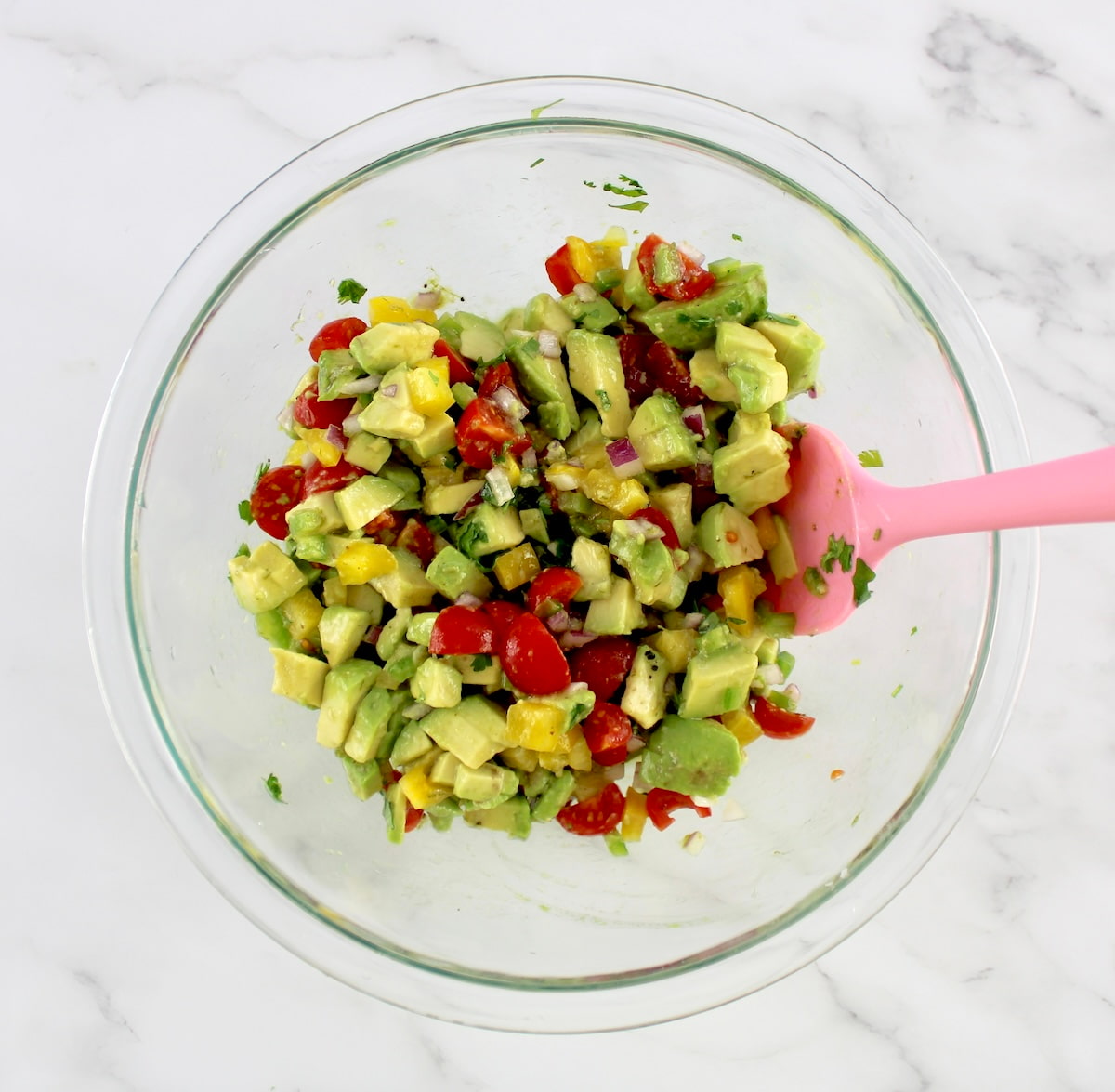 Avocado Salsa in glass bowl with pink spoon