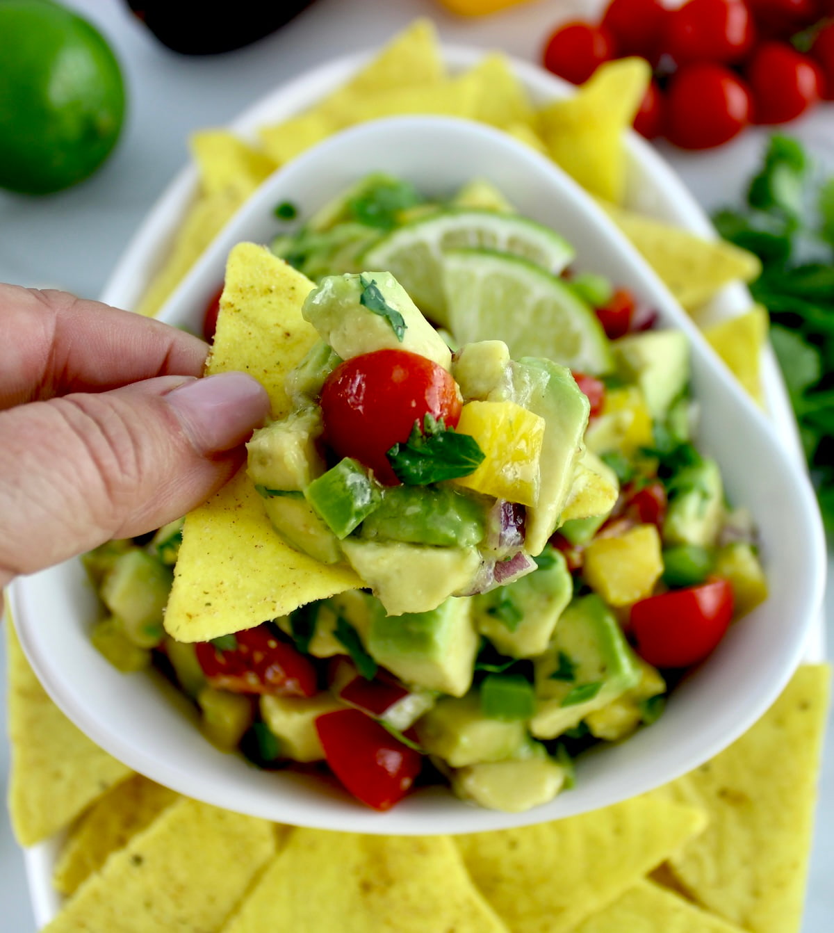 holding up Avocado Salsa on tortilla chip