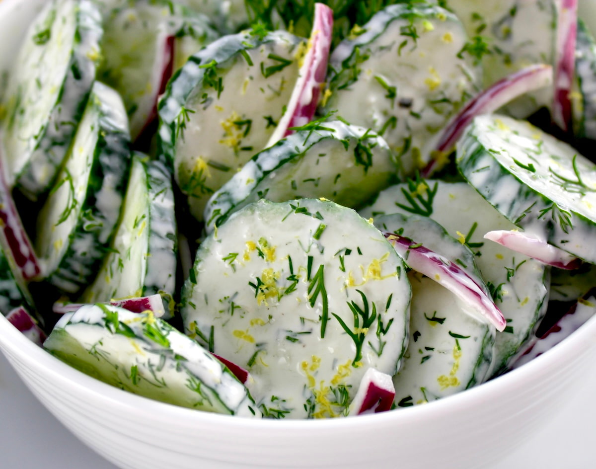 closeup of Creamy Cucumber Salad in white bowl