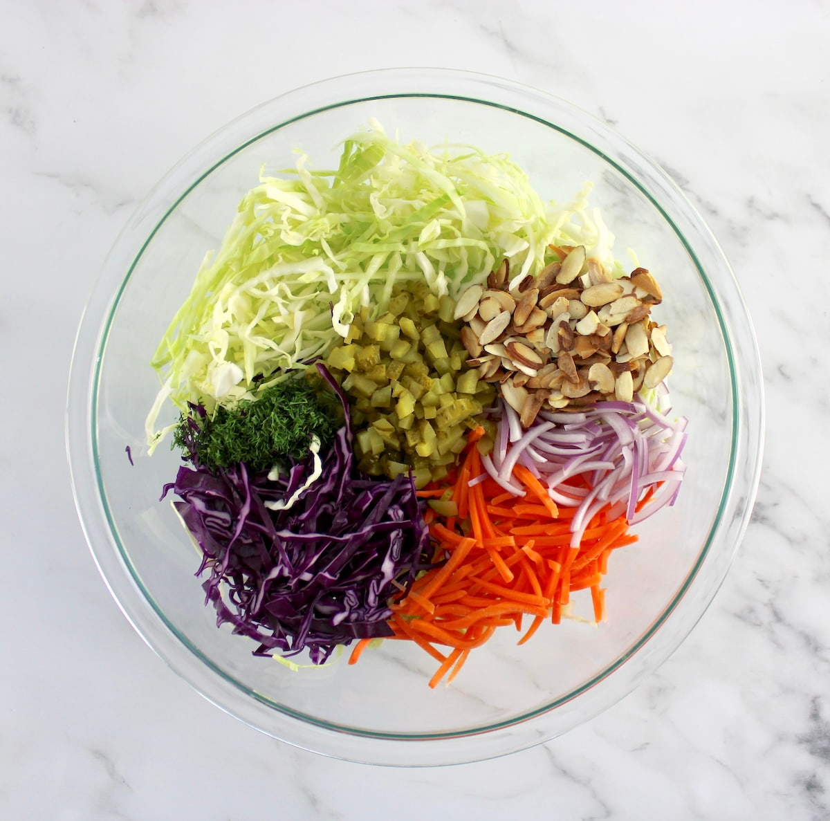 Dill Pickle Coleslaw ingredients in glass bowl in sections
