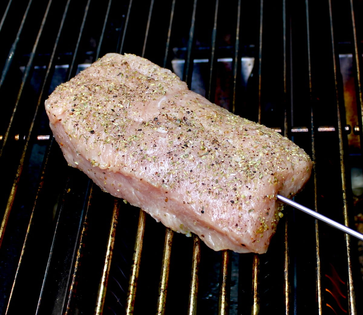 raw pork tenderloin on grill with olive oil, dried oregano, salt and pepper