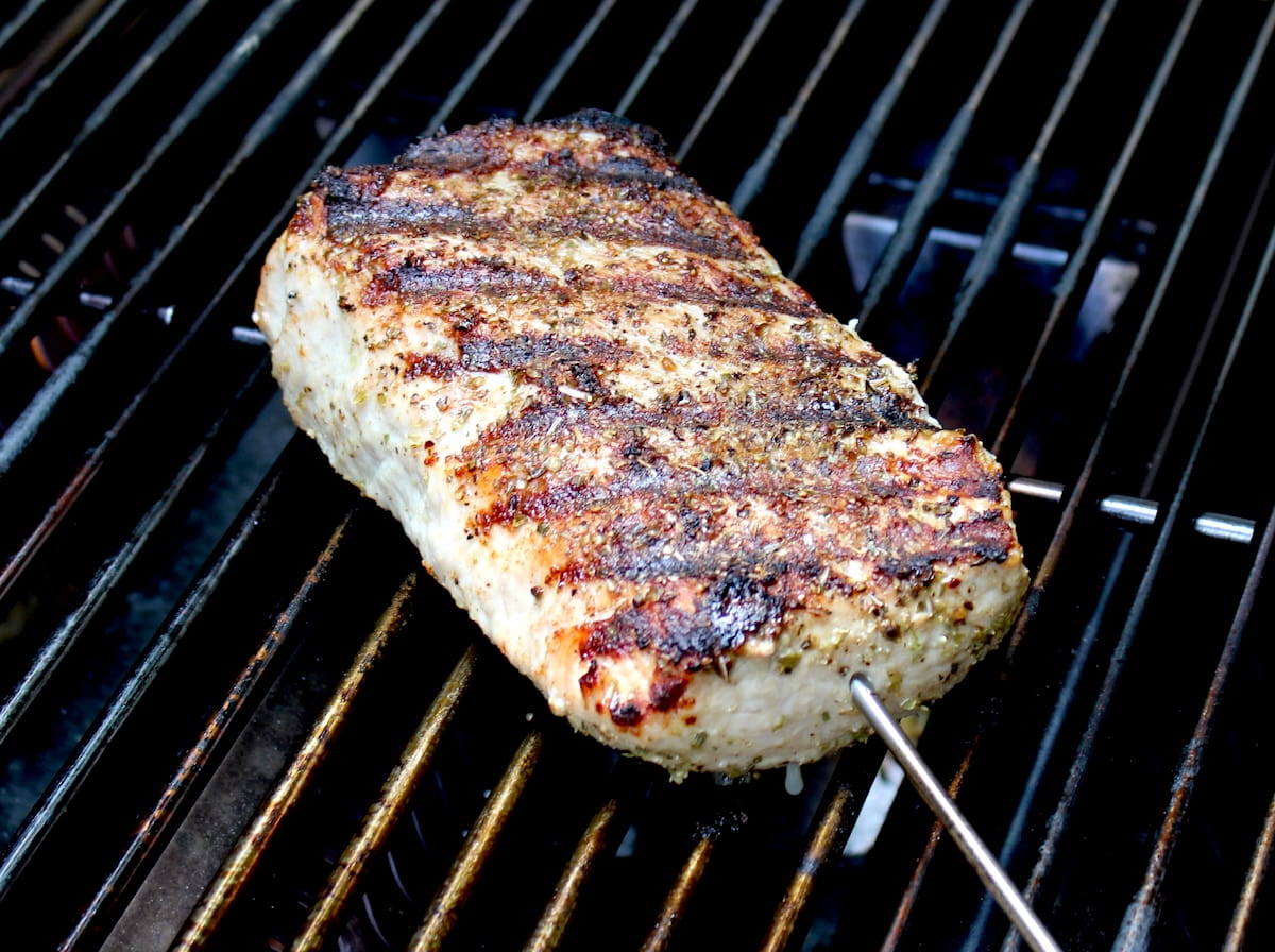 cooked pork tenderloin on grill with olive oil, dried oregano, salt and pepper