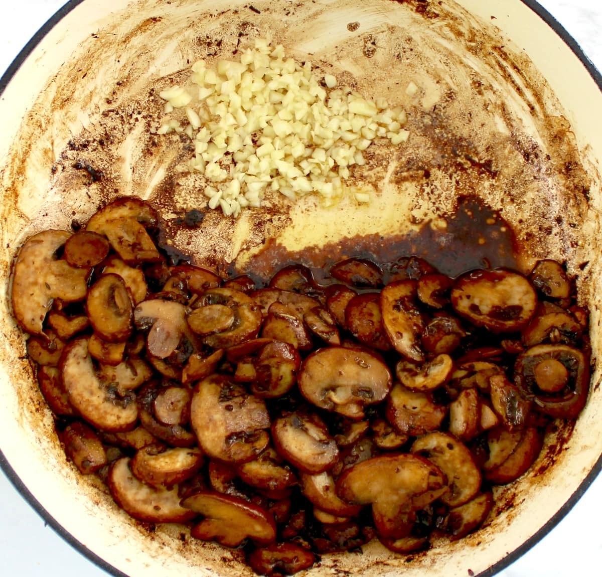 sauteed mushrooms in skillet with minced garlic