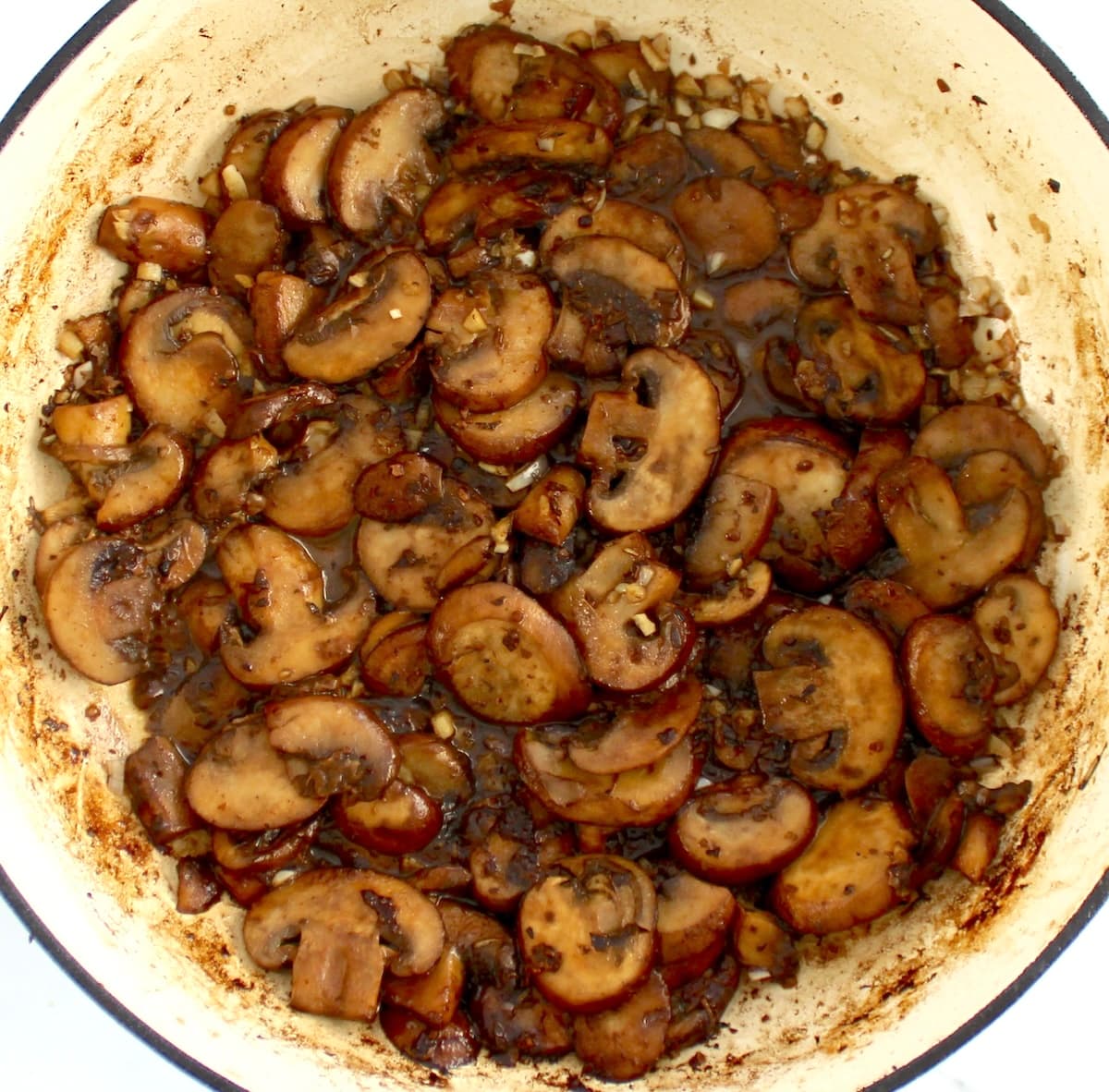 sauteed mushrooms in skillet with white wine