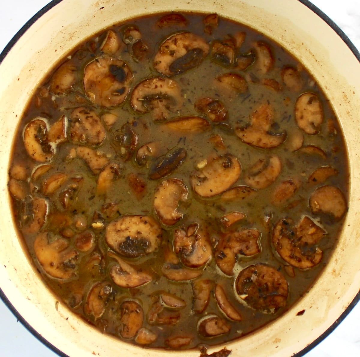 sauteed mushrooms in skillet with broth