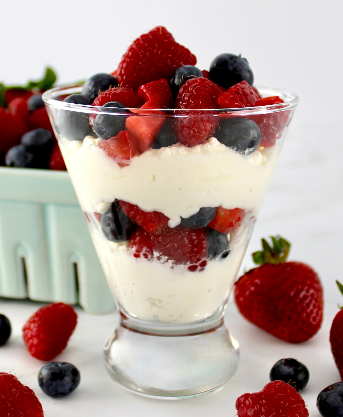 side view of Keto Berries and Cream in layers in glass with berries in back