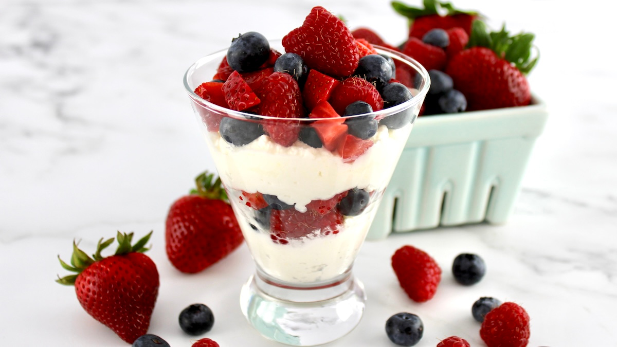 side view of Keto Berries and Cream in layers in glass with berries in back