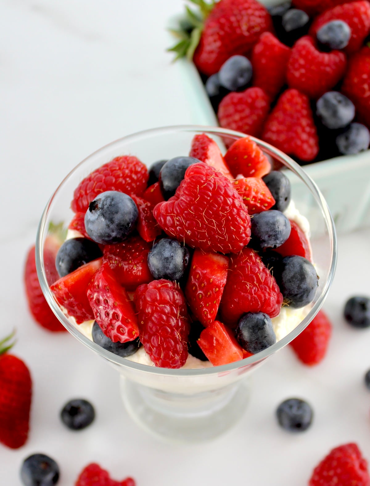 overhead view of Keto Berries and Cream in glass with berries on top and in back