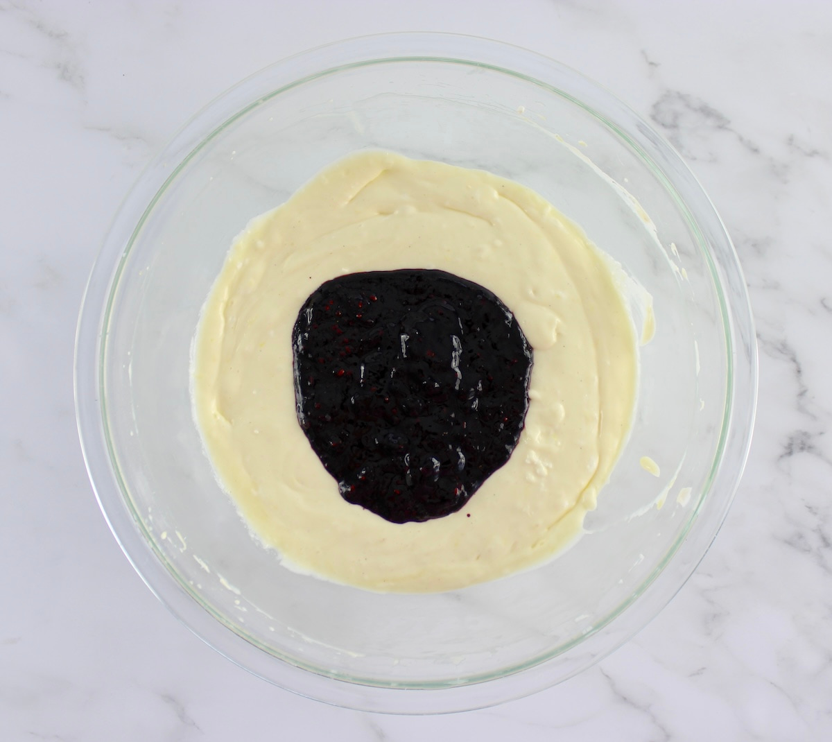 cheesecake filling with pureed blackberries on top unmixed