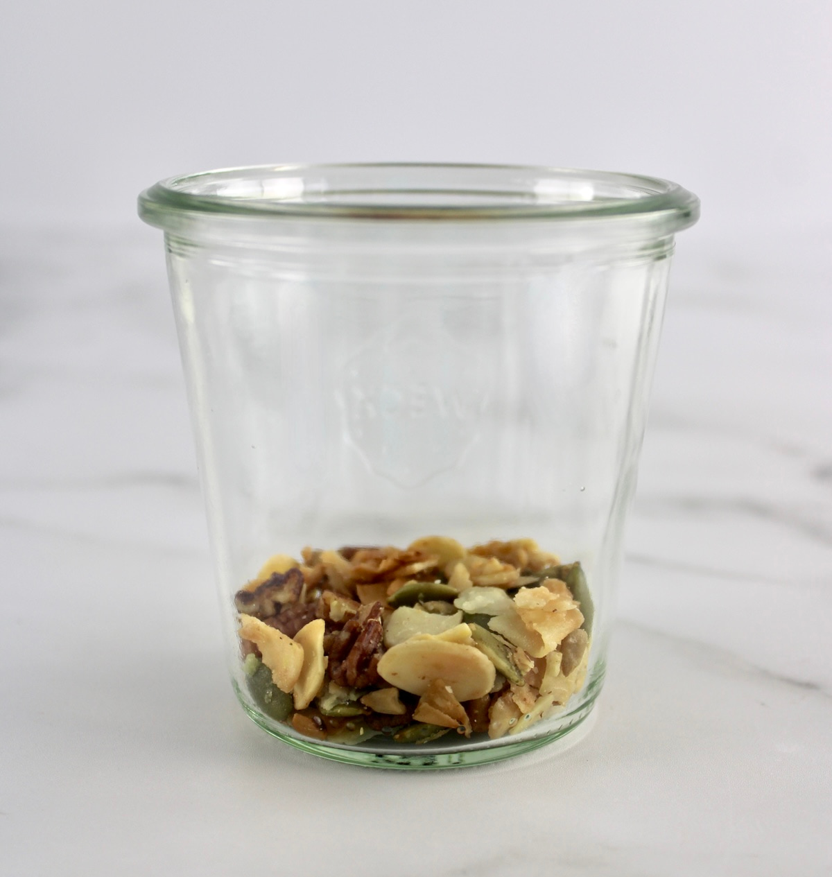 side view of open glass jar with keto granola on bottom