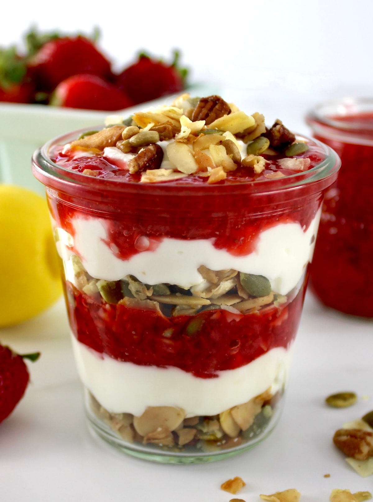 closeup side view of Keto Strawberry Granola Parfait in open glass jar