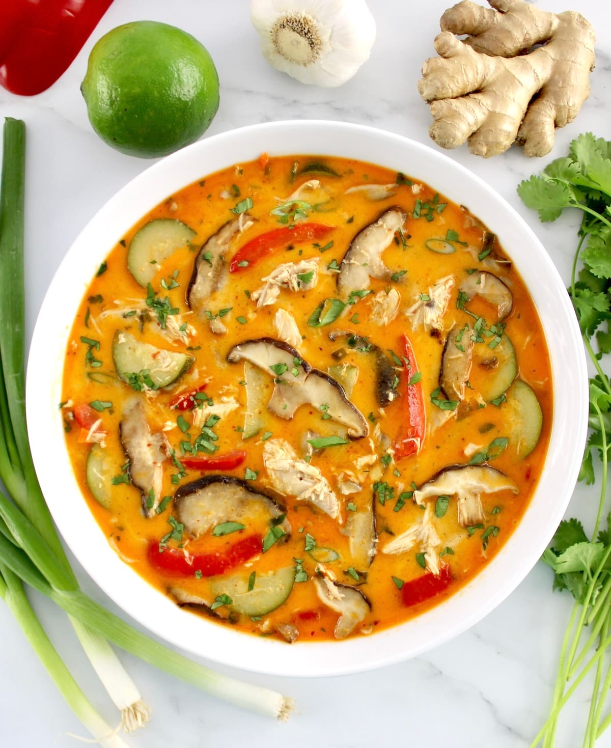 overhead view of Thai Coconut Curry Chicken Soup in white bowl