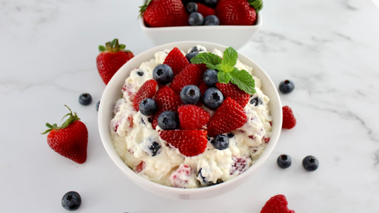 overhead view of berry cheesecake salad with berries and mint sprig on top