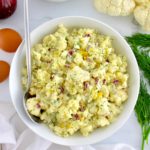 Cauliflower Potato Salad in white bowl with serving spoon