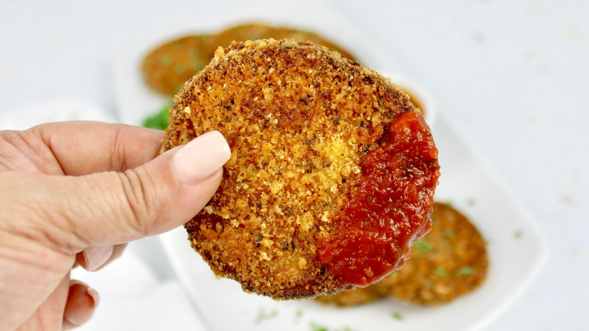 slice of breaded eggplant round that had been dipped in marinara sauce