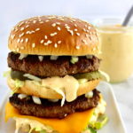 Keto Big Mac on white plate with sauce in back