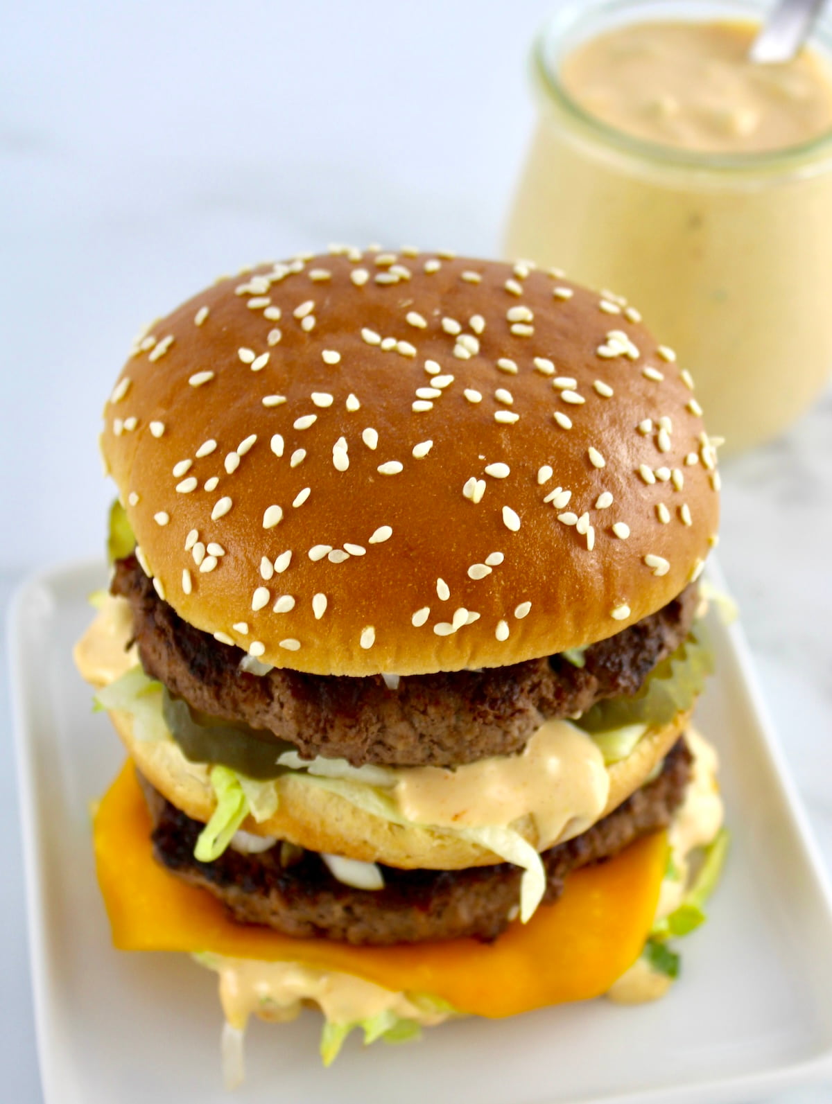 overhead view of Keto Big Mac on white plate with sauce in back