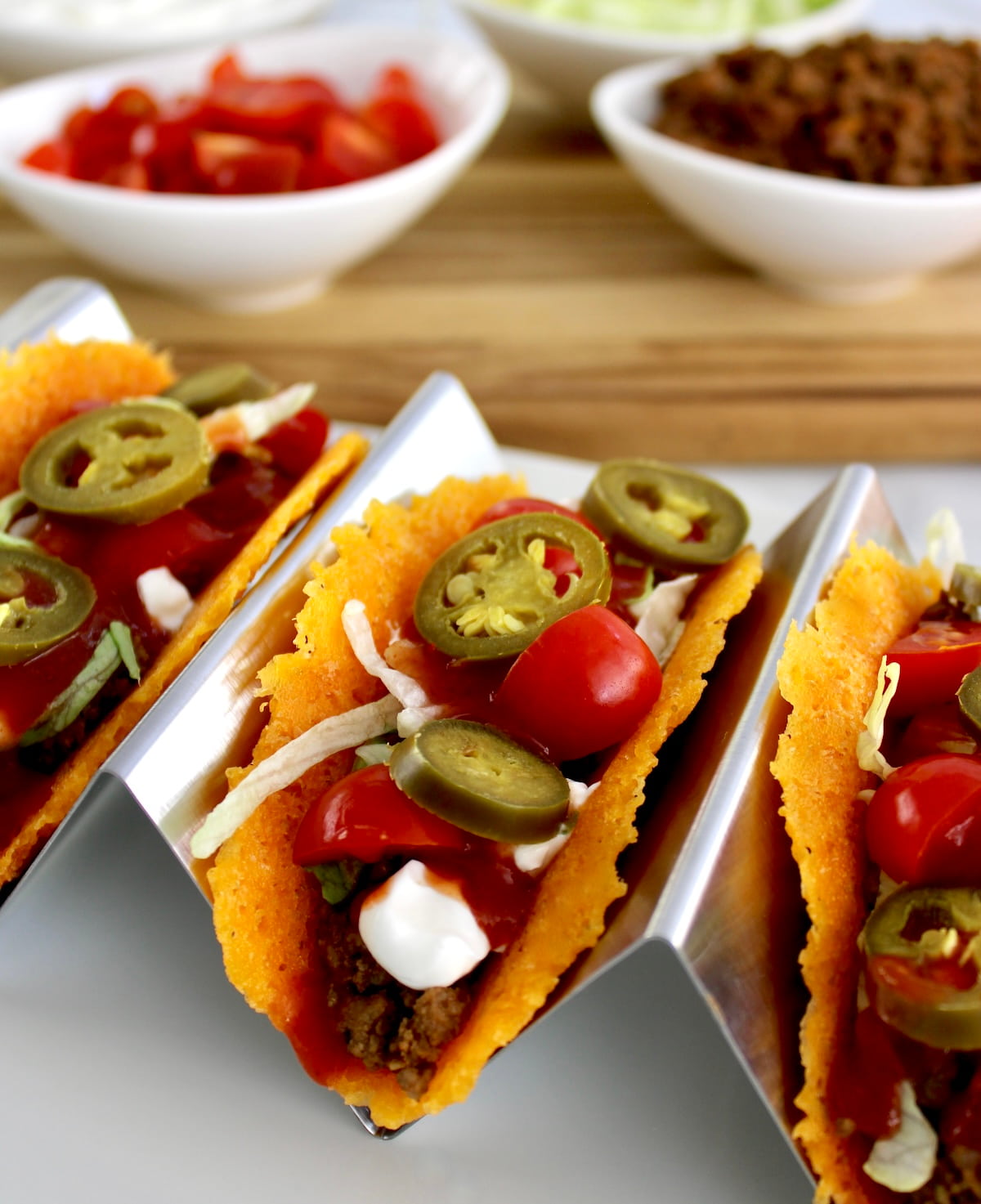 Keto Cheese Tacos in taco holder with toppings in white cups in back