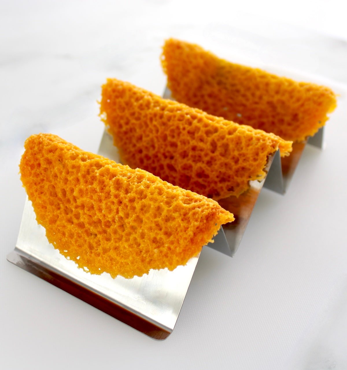 3 Keto Cheese Taco Shells on metal taco holder