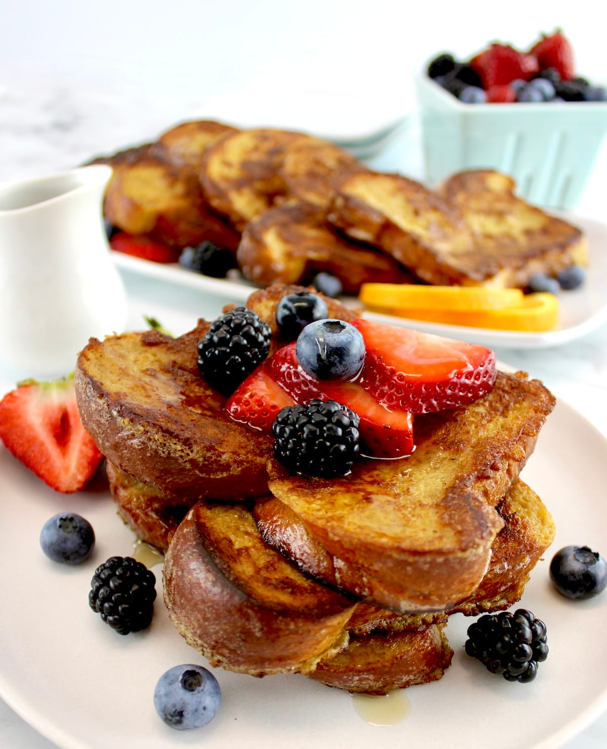 closeup side view of Keto French Toast on white plate with fresh berries