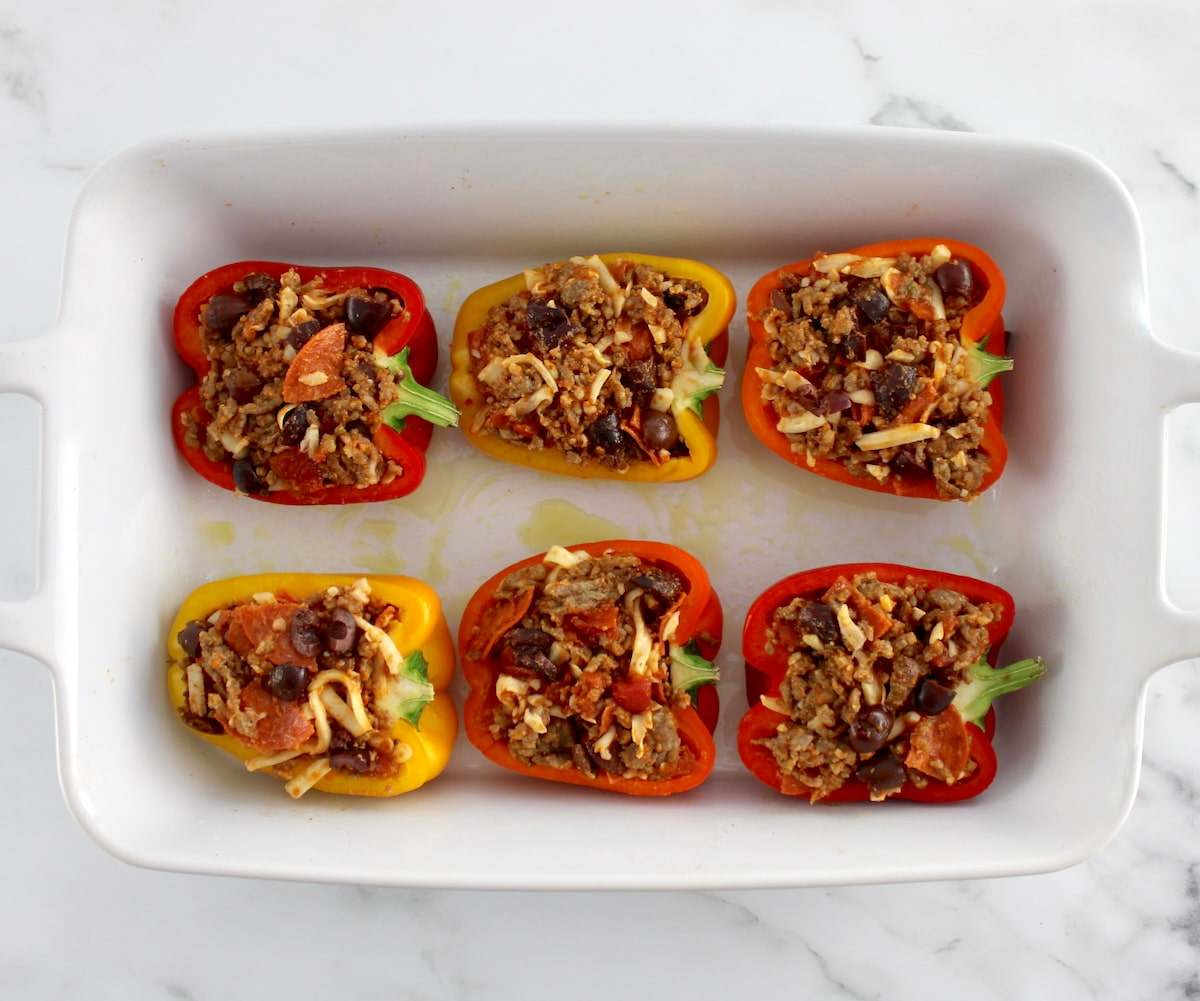 Pizza Stuffed Peppers in white casserole dish unbaked