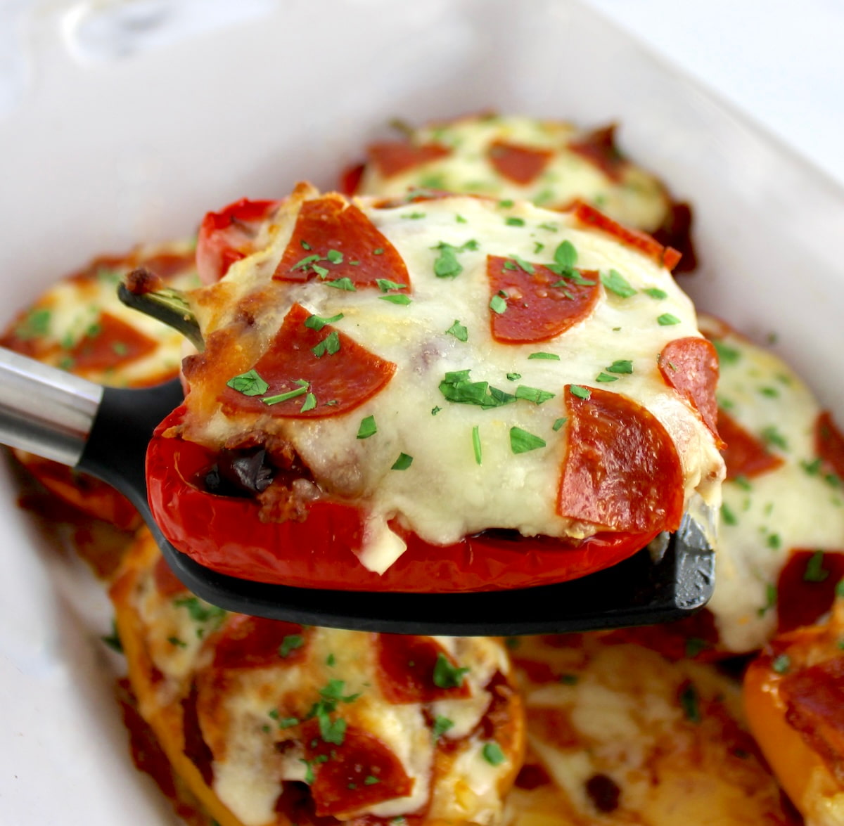 spatula holding up Pizza Stuffed Pepper over casserole
