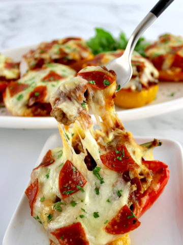 fork pulling up cheese in Pizza Stuffed Pepper on white plate