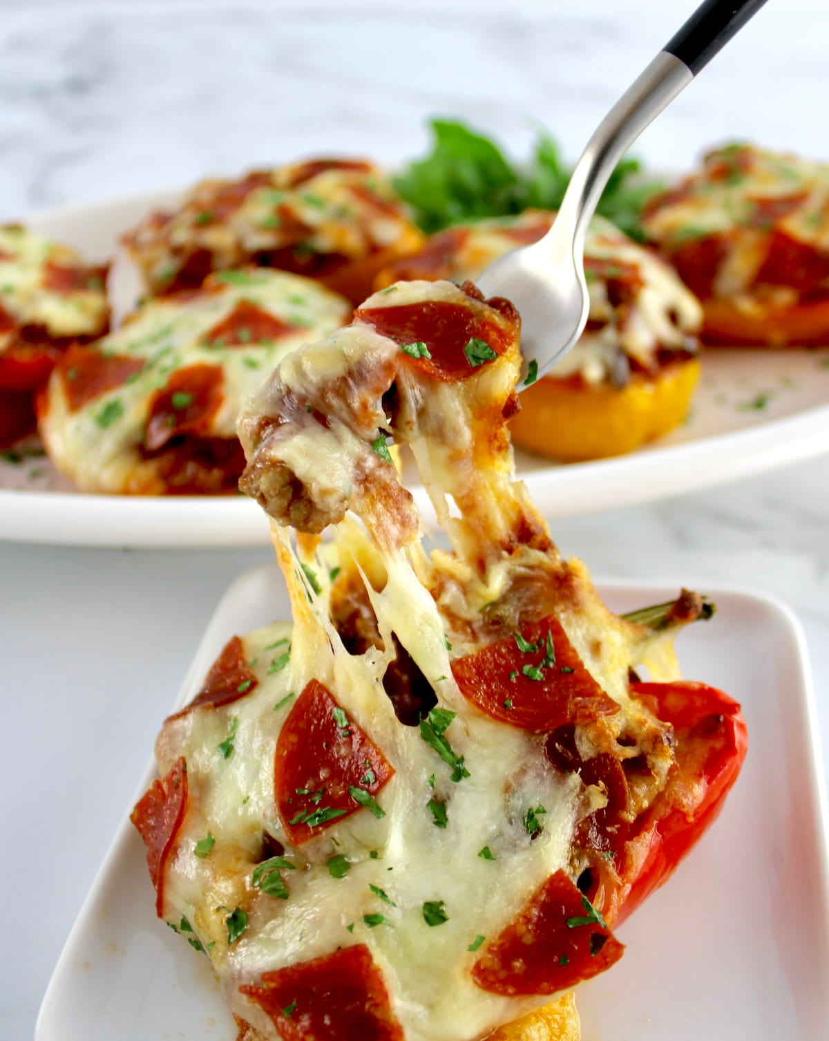fork pulling up cheese in Pizza Stuffed Pepper on white plate
