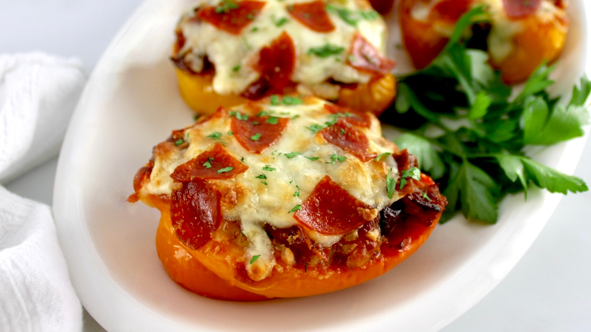 closeup of Pizza Stuffed Pepper on white plate with fresh parsley