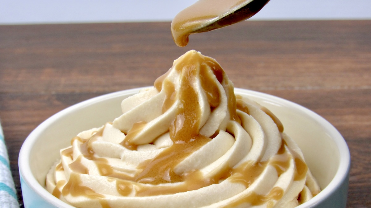 caramel dripping over mousse in blue bowl