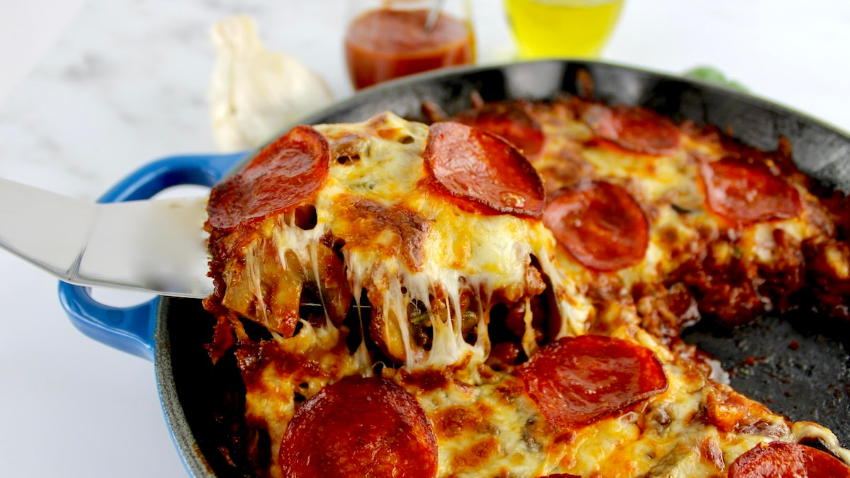 crustless pizza piece being lifted out of skillet