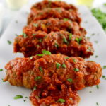 Italian Beef Braciole on long white plate with chopped parsley