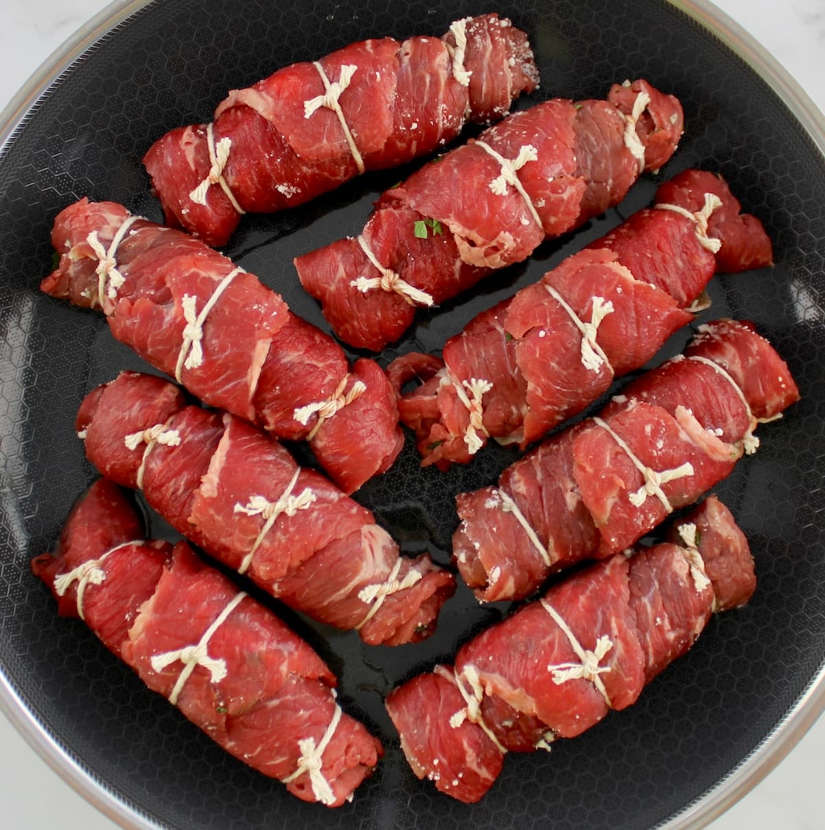 8 pieces of uncooked Italian Beef Braciole in skillet