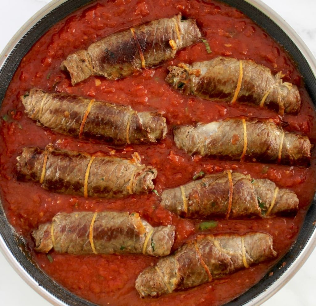 8 pieces of Italian Beef Braciole in skillet with tomato sauce