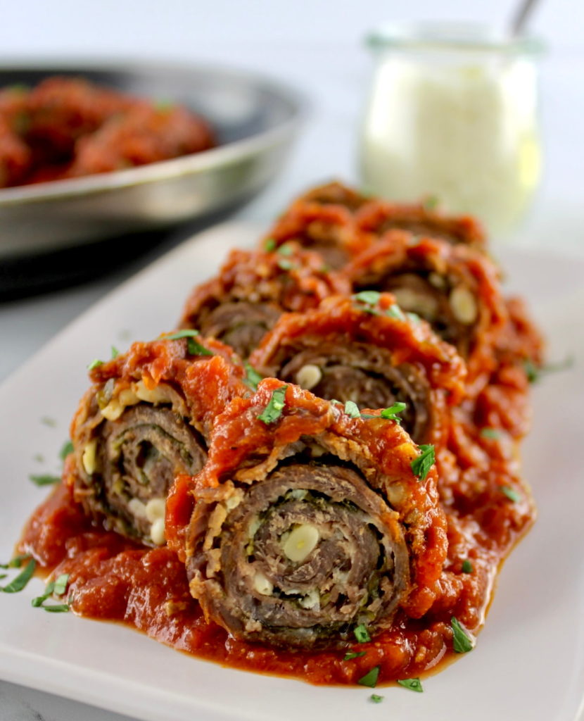 Italian Beef Braciole sliced into pinwheels on white plate