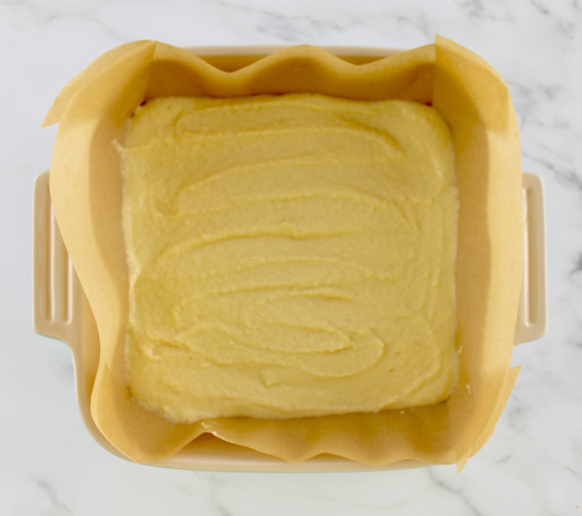 Keto Coffee Cake batter in baking dish lined with parchment paper