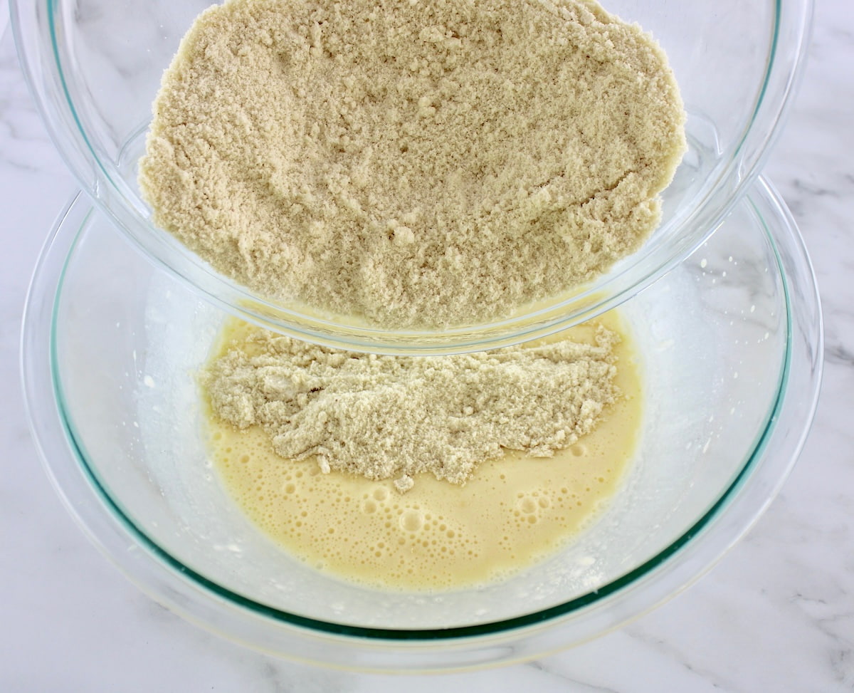 dry ingredients for Keto Coffee Cake being poured into the wet in glass bowl